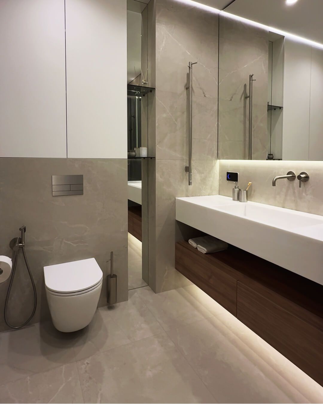 Сучасний санвузол із великоформатною плиткою бежевого відтінку, дзеркальною нишею з поличками