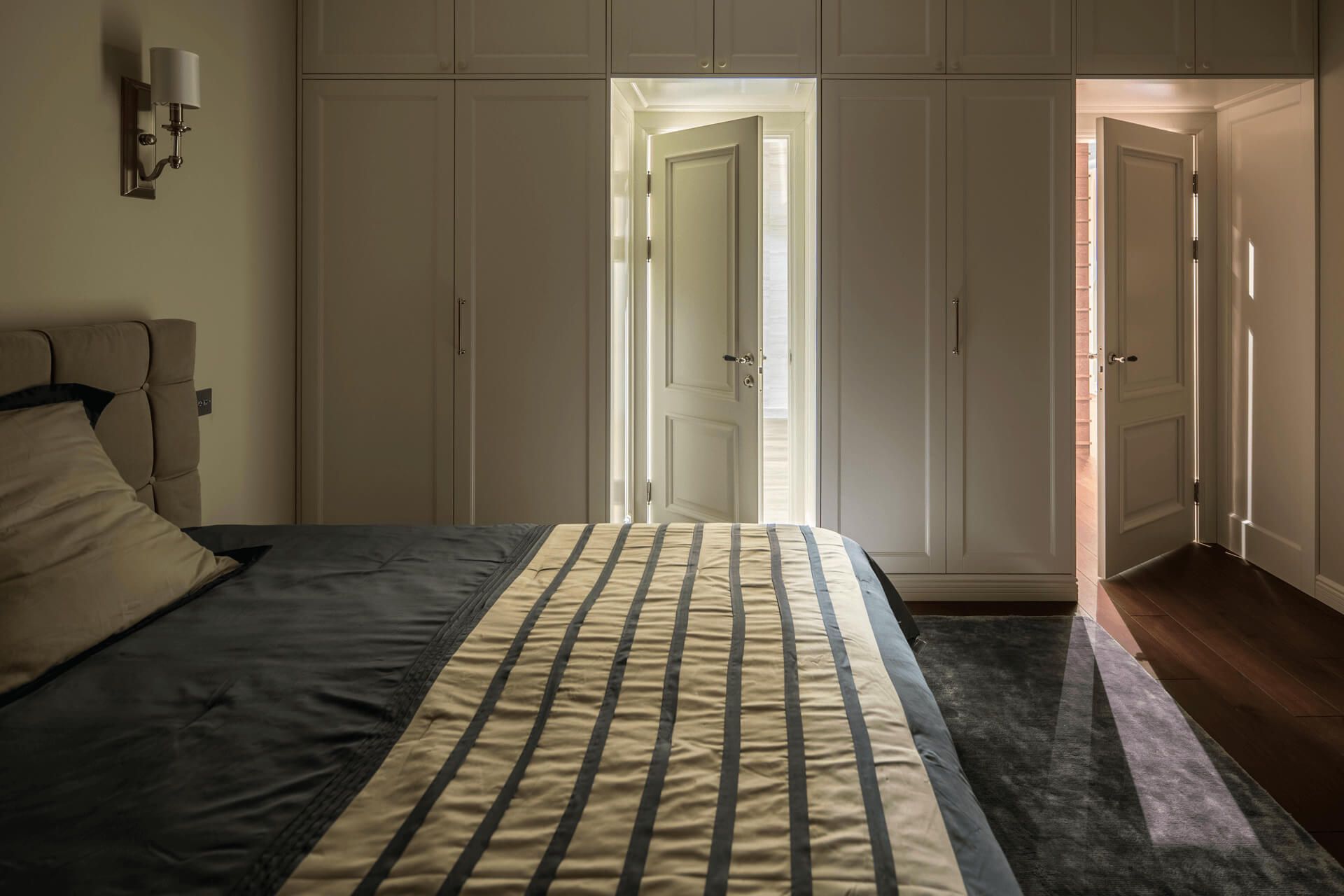 Спальня з великим ліжком із м'яким узголів'ям, вбудована шафа та окремий санвузол