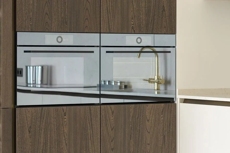 Дві духові шафи з дзеркальним склом, вбудовані в меблі зі шпонованими фасадами темного дерева