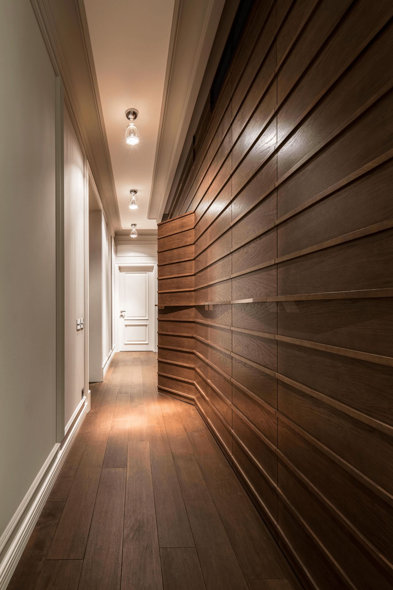 Коридор з дерев’яними стіновими панелями, точкові світильники, паркет