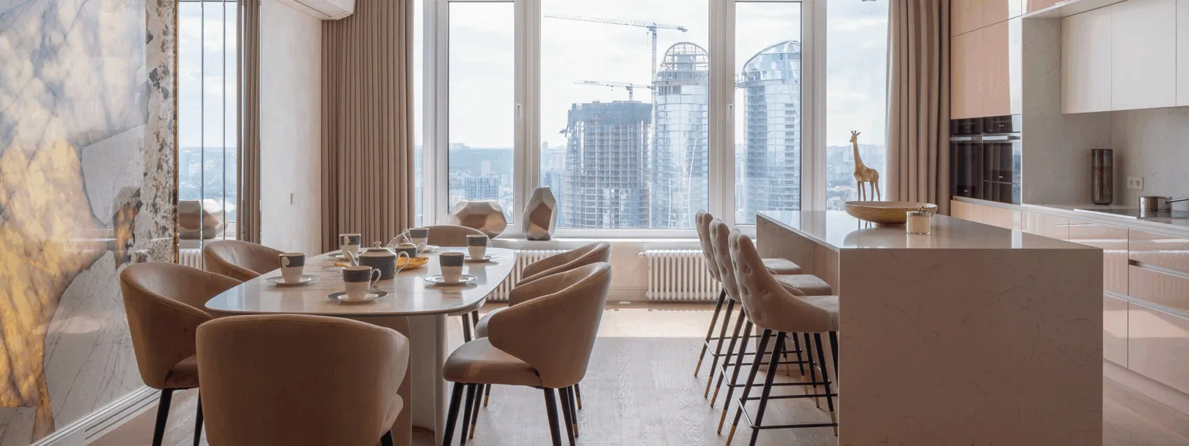 Дизайнерська кухня-вітальня; стильне мармурове оздоблення; на столі чайний сервіз