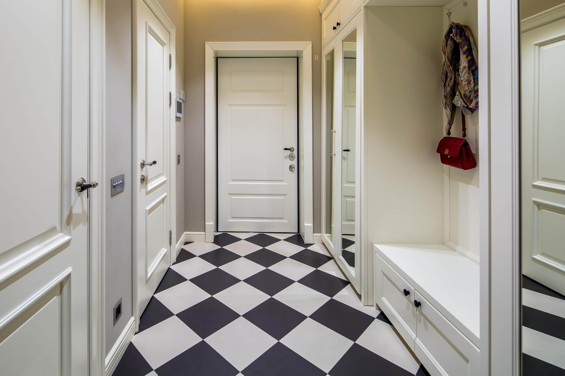 Передпокій з шахматною плиткою, шафою з дзеркалом і білими дверима, тумблерний вимикач