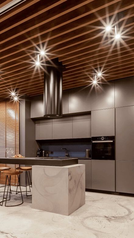 Кухня, матові фасади кавового віддінку, острівець з варильною поверхнею, високі стільці, акцентна графітова витяжка