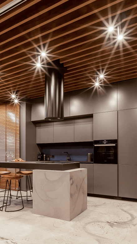 Кухня, матові фасади кавового віддінку, острівець з варильною поверхнею, високі стільці, акцентна графітова витяжка