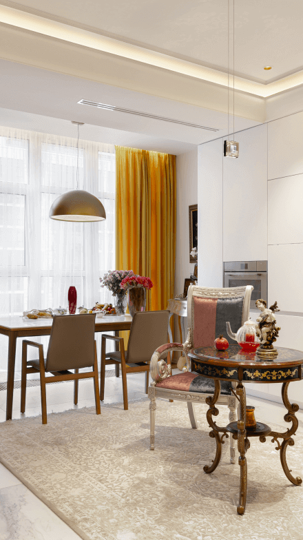 Кухня-вітальня, плитка під білий мармур на підлозі, біла кухня, стілець і кавовий стіл в класичному стилі, жовті штори