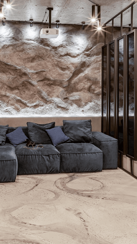 М'якмй куточок, кіно-проєктор під стелею, декоративна штукатурка на стіні під скальну породу