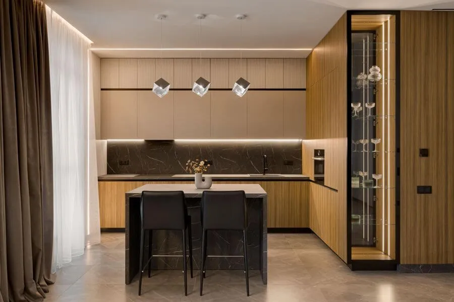 Кухня-вітальня з островом, дизайнерськими світильниками кубічної форми, кухонними фасадами зі шпонованого МДФ