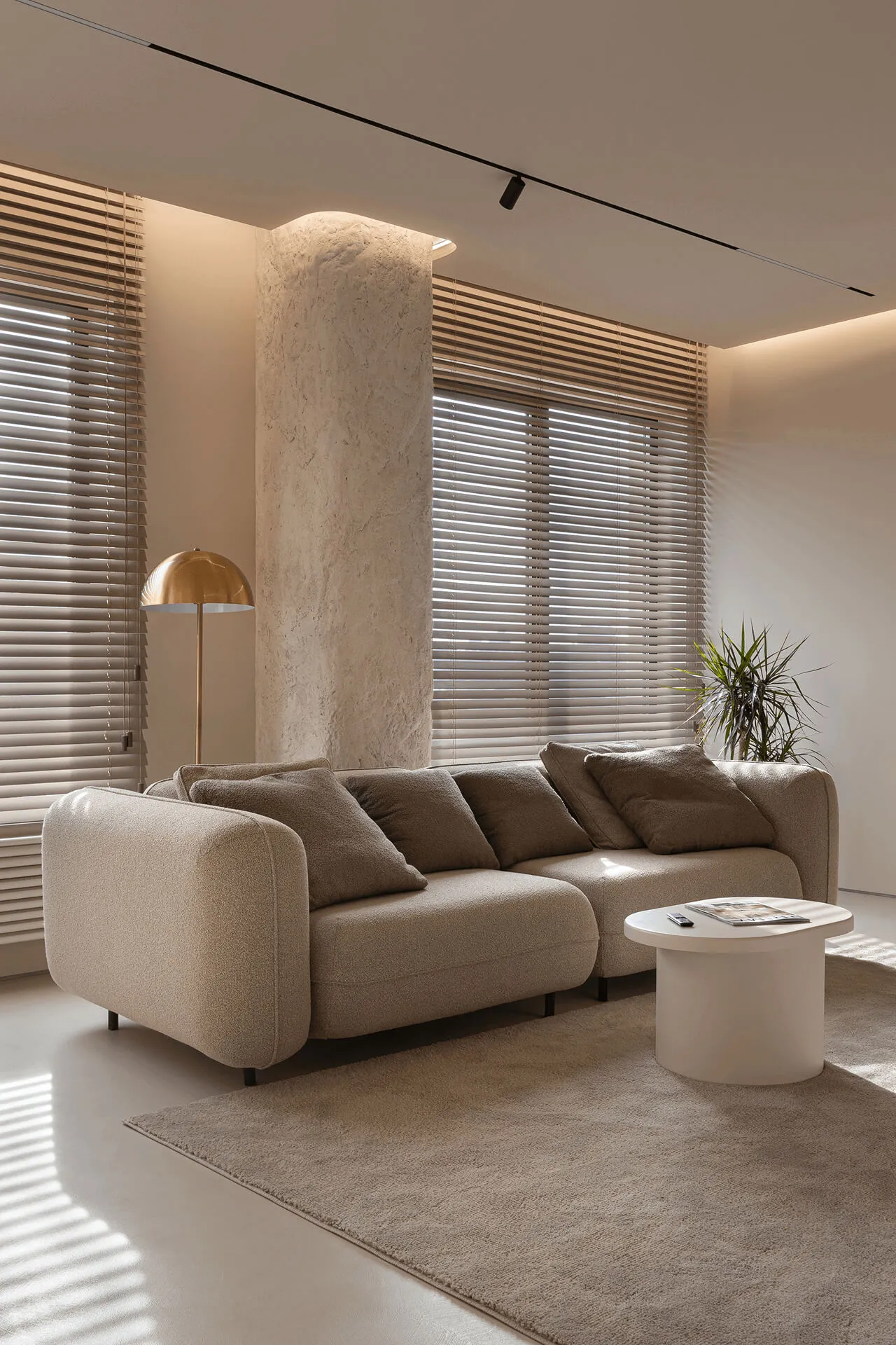 Вітальня з м’яким диваном, кремовим журнальним столиком і торшером у формі гриба