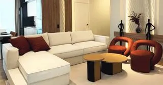 Зона відпочинку у вітальні з теракотовими кріслами, декоративною стіною та чорними фігурами, Unit.City, Київ