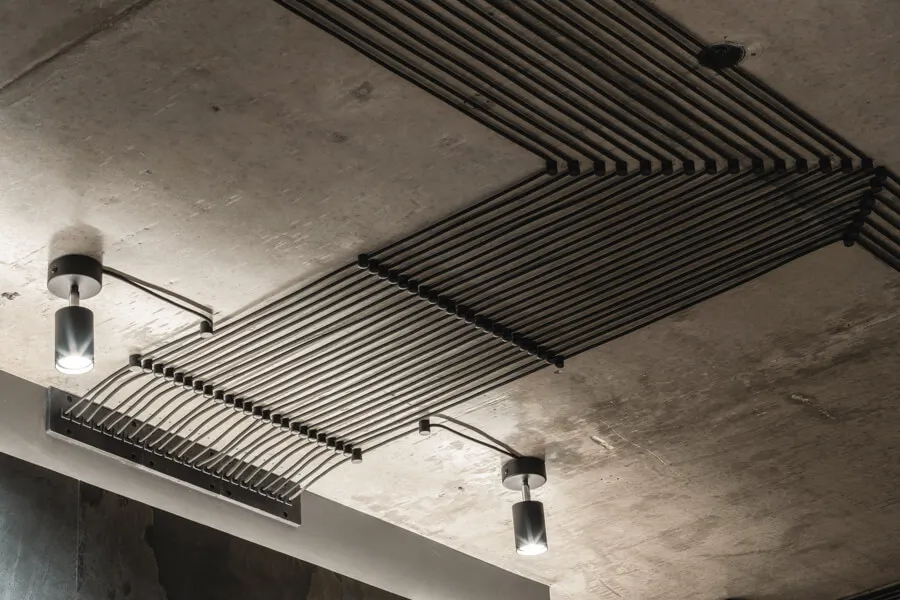 Стиль лофт з бетонною стелею, точковими світильниками з відкрито прокладеними електрокабелями