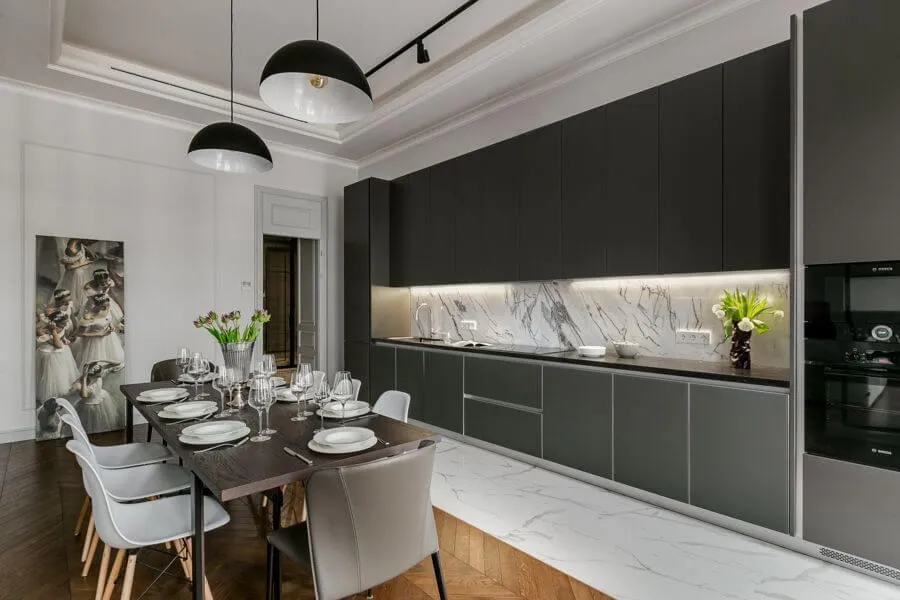 Кухня з обідньою зоною, темно-зеленими фасадами, фартухом під білий мармур і комбінованою підлогою паркет-керамограніт