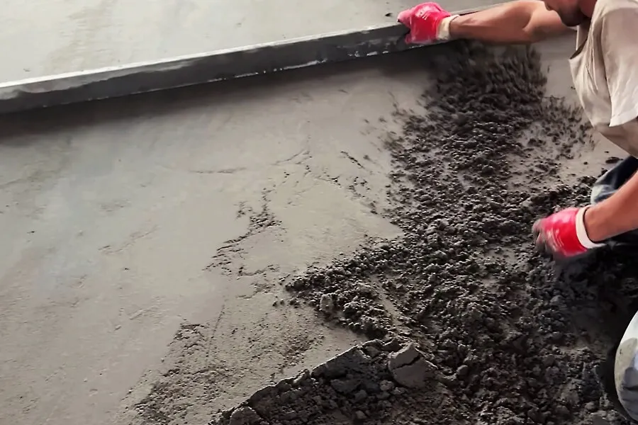 Ручне вирівнювання стяжки металевою рейкою (правилом)