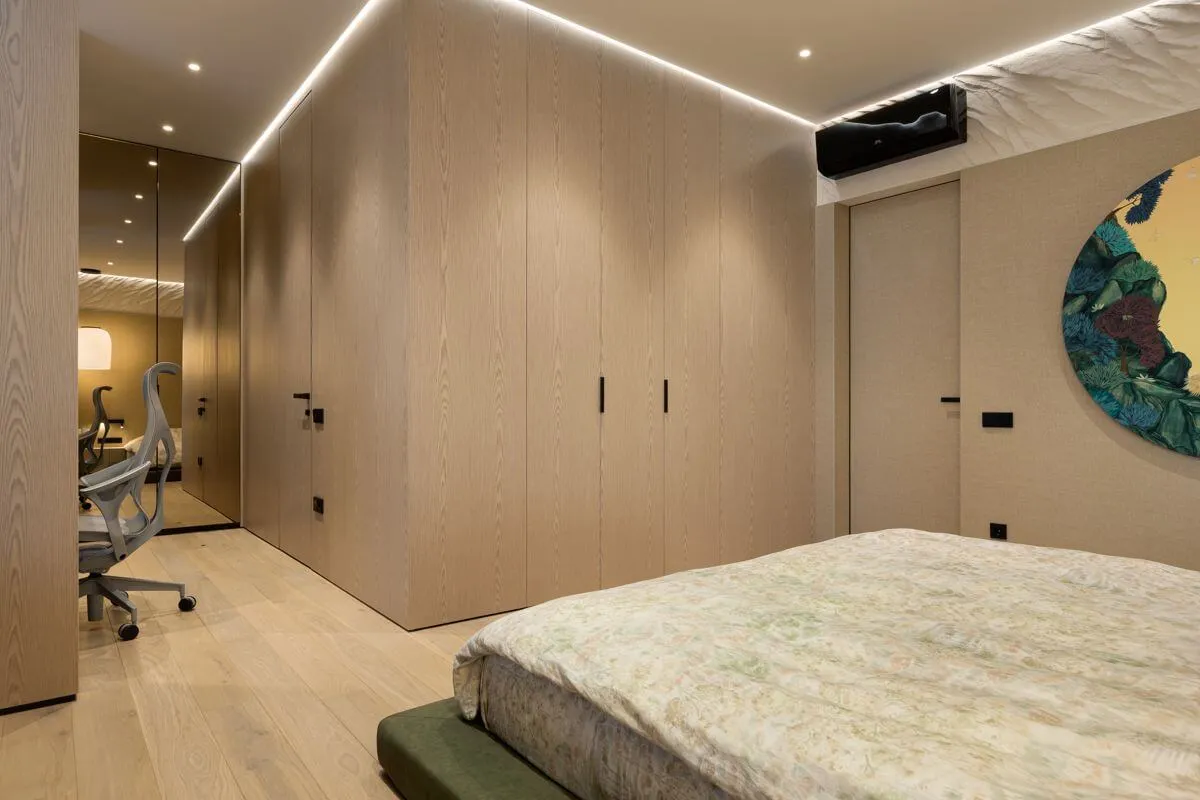 Майстер-спальня зі стеновими панелями двох видів: шпоном світлого дуба та тканинним покриттям