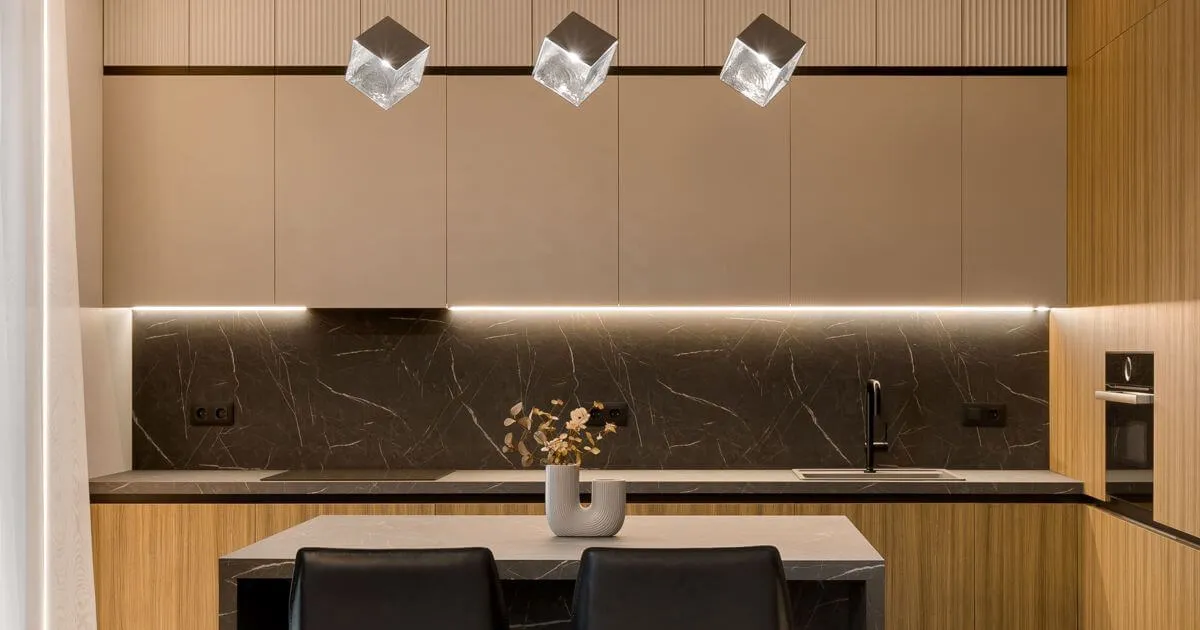 Інтер'єр сучасної кухні: темно-сірі шафи, стільниця та фартух з великоформатного керамограніту під граніт, скляні світильники