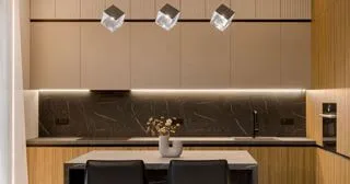 Інтер'єр сучасної кухні: темно-сірі шафи, стільниця та фартух з великоформатного керамограніту під граніт, скляні світильники