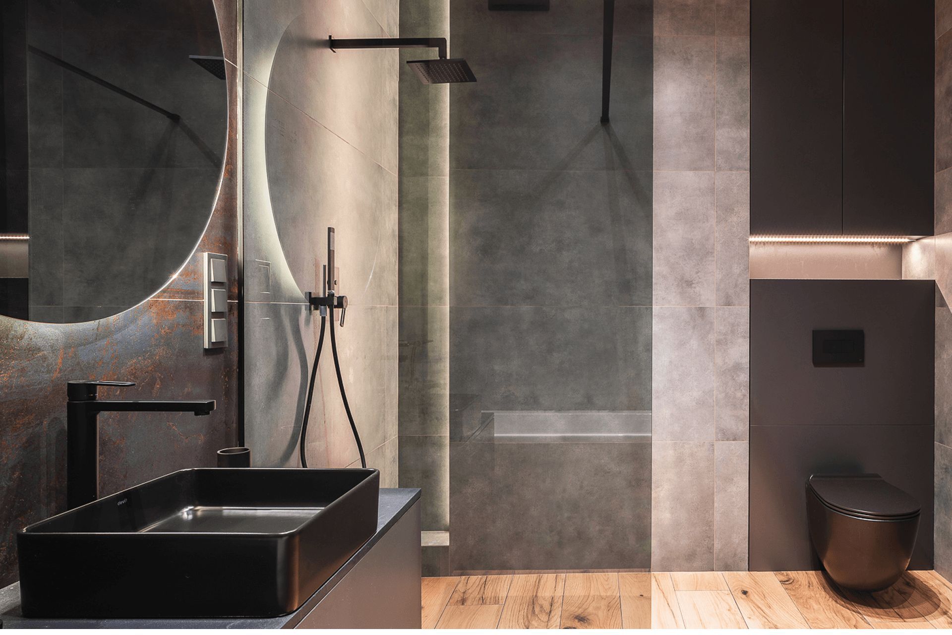 Стильний інтер'єр санвузла в темних тонах з круглим дзеркалом та прихованою інсталяцією