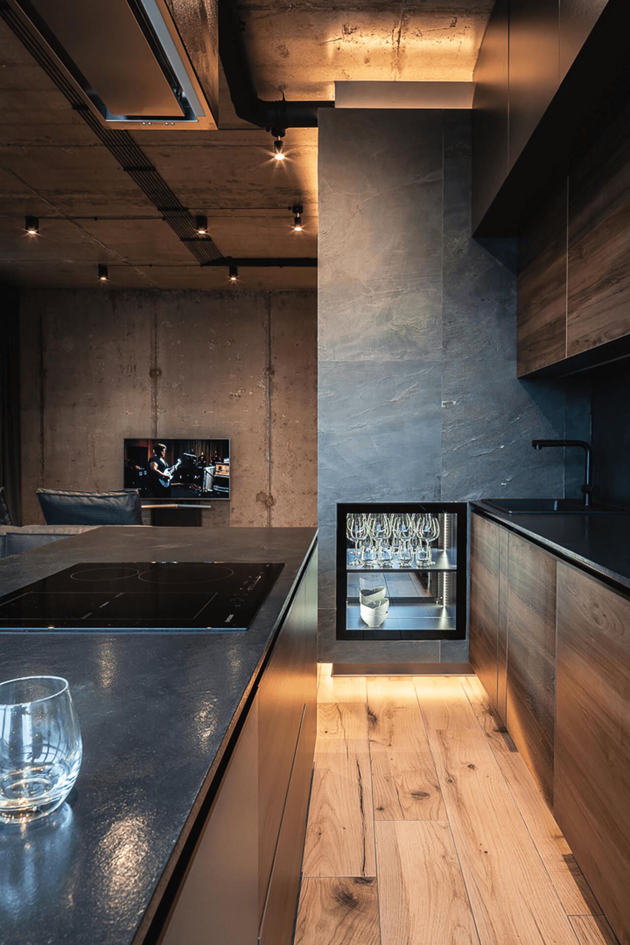 Кухня в стилі лофт з бетонною стелею, світлим паркетом, дерев'яними фасадами меблів і островом з вбудованою варильною поверхнею