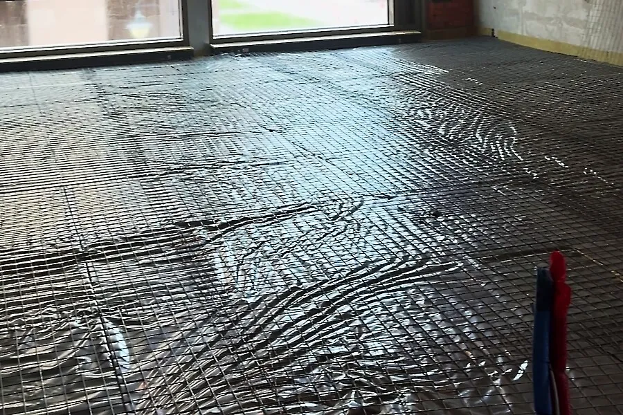 Підлога накрита плівкою на якій розміщена армуюча сітка готова для нанесення стяжки