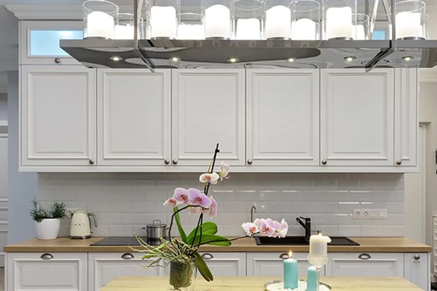 Кухня з білими фацетованими фасадами і фартухом з білої прямокутної керамічної плитки метро