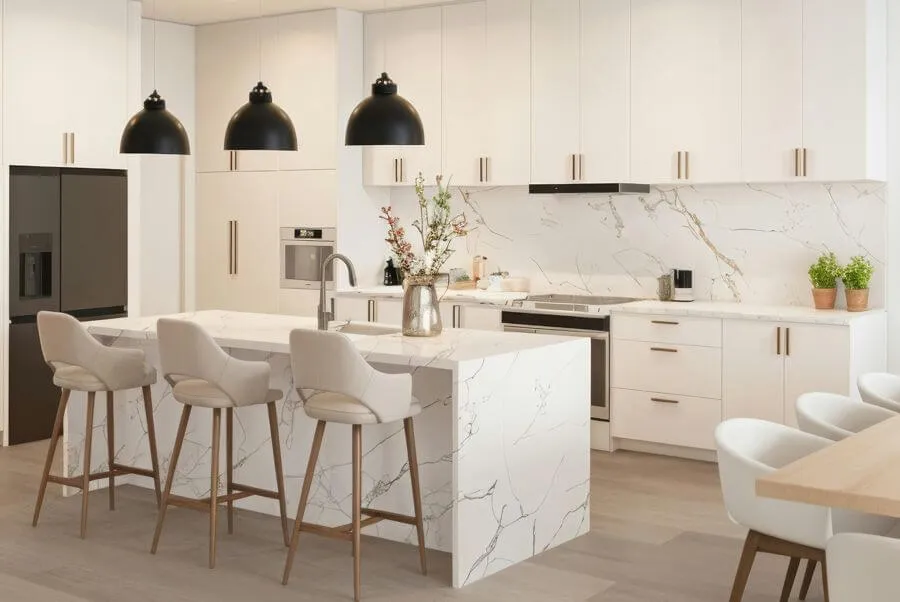 Сучасна світла кухня з білою стільницею та високими стільцями біля острова
